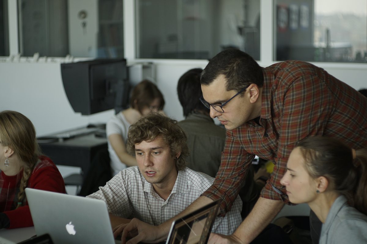 Paul Catanese working at a computer with workshop participants in Wrocław